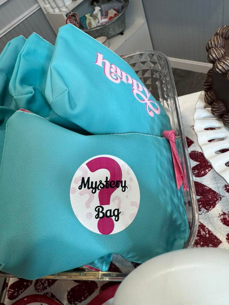 MYSTERY BAGS. Filled with goodies. All items are tucked into a teal bag with a gold and pink zipper. Each with the word Happy printed.