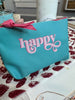 MYSTERY BAGS. Filled with goodies. All items are tucked into a teal bag with a gold and pink zipper. Each with the word Happy printed.